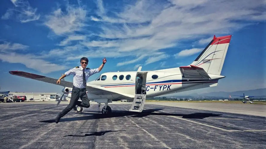 pilot doing a jumpshot with an airplane behind him