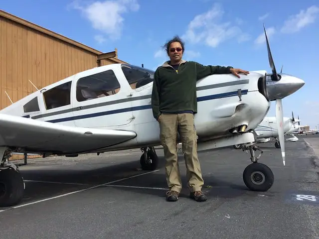 Pilot beside a white plane