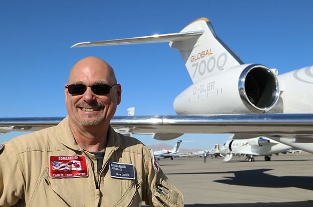 smiling pilot and plane on his background