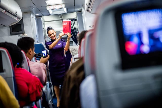 Flight Attendant demonstrating in front of passengers