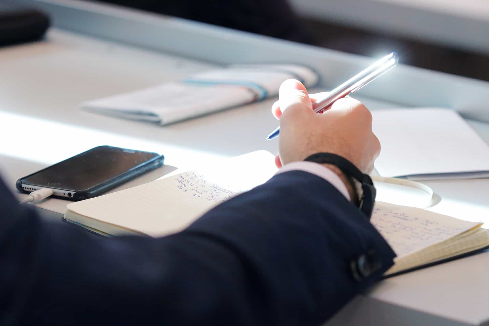 man holding a metallic pen